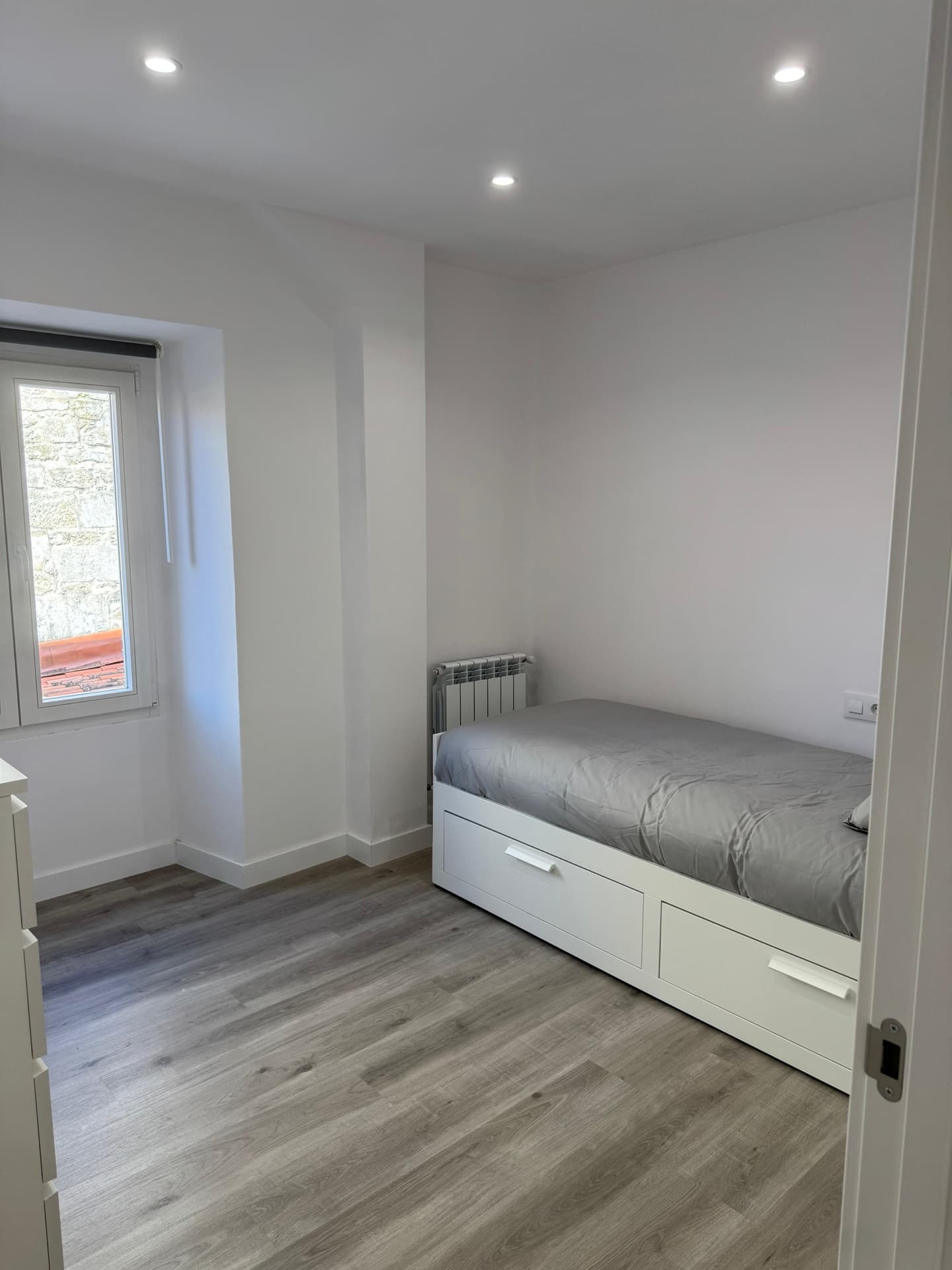 Dormitorio con camas individuales y ventana al exterior