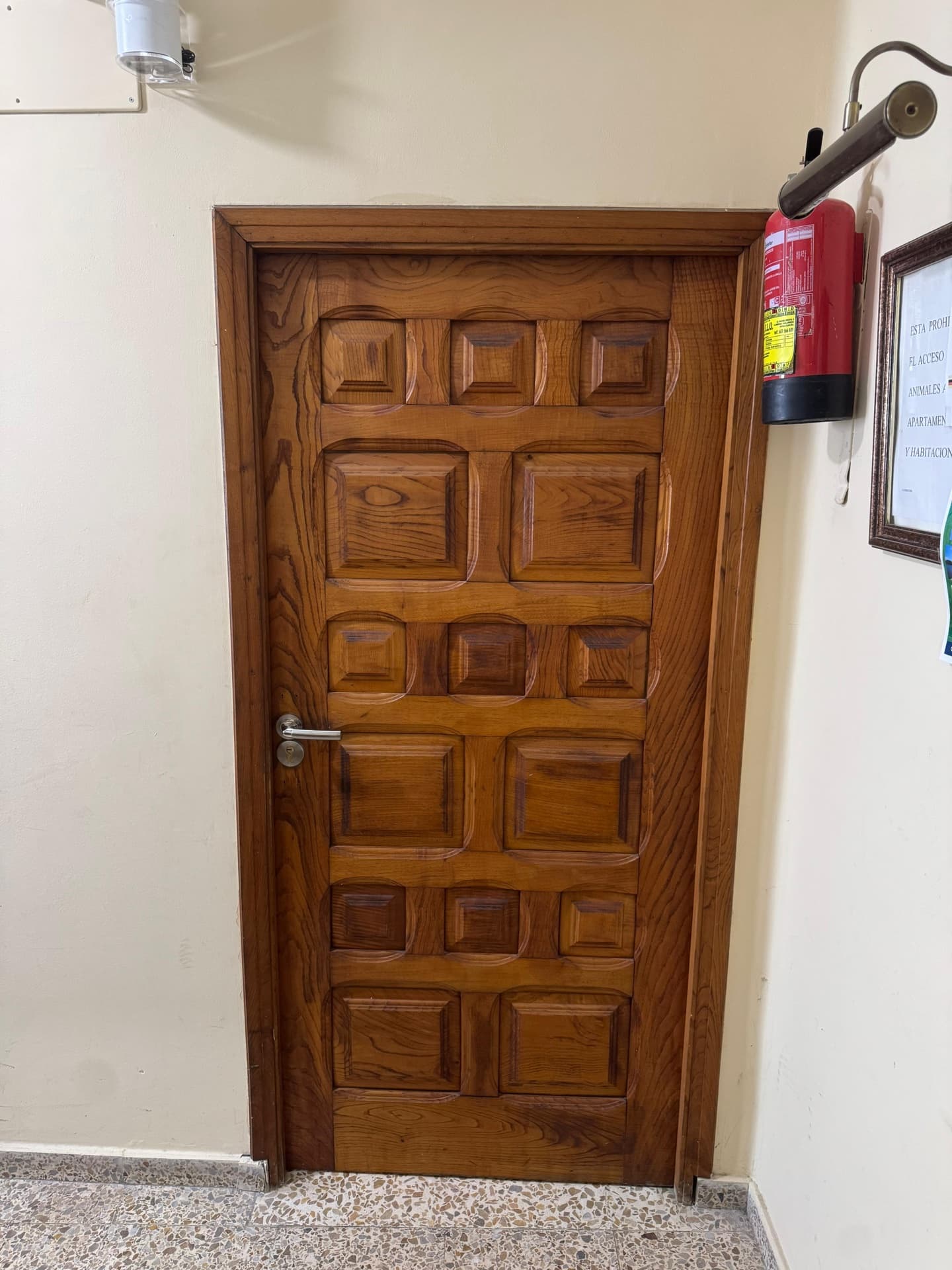 Entrada del apartamento con puerta clásica de madera